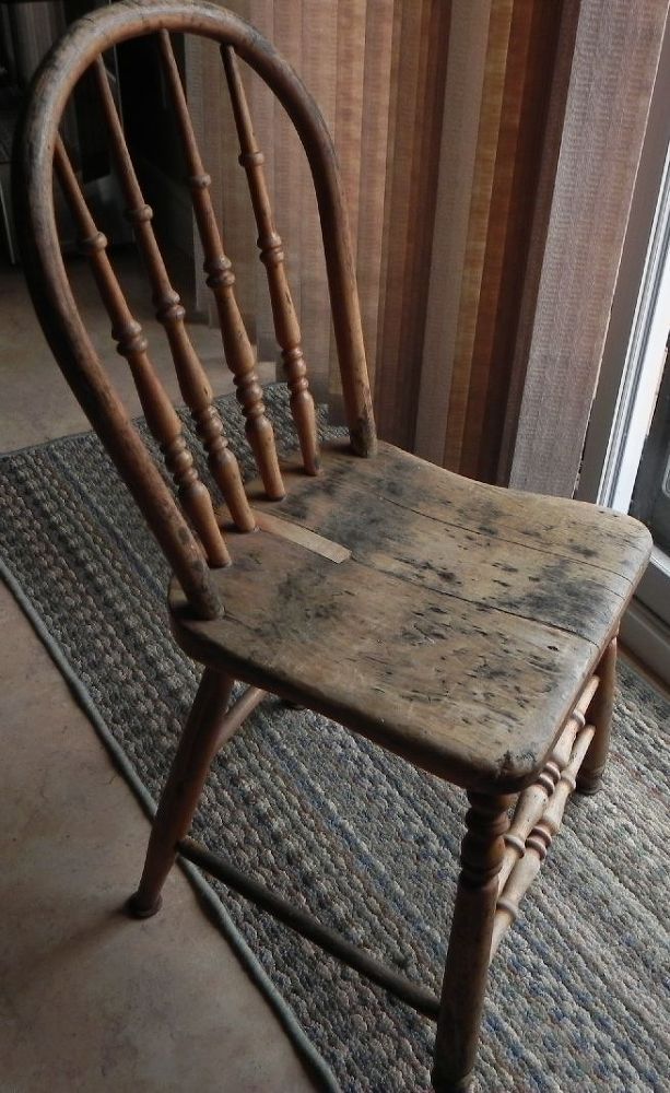 an old wooden rocking chair sitting on top of a rug in front of a window