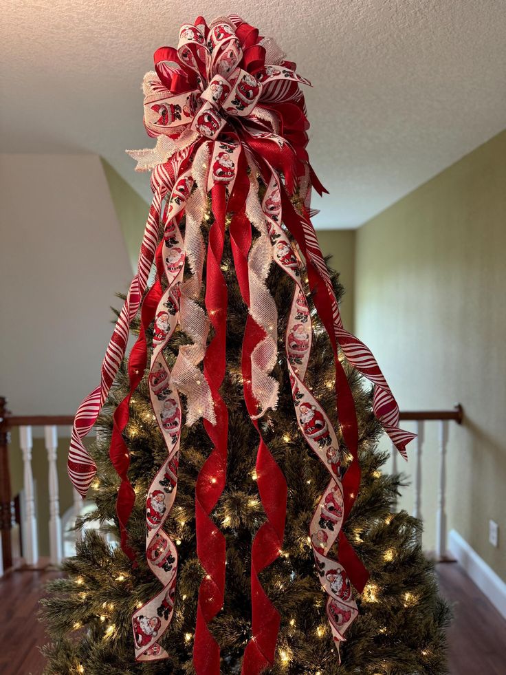 a decorated christmas tree with red and white ribbons