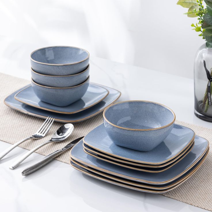 a table set with blue dishes and silverware