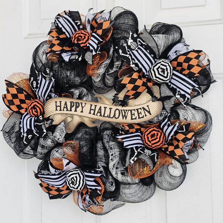 a halloween mesh wreath with the words happy halloween hanging on it's front door