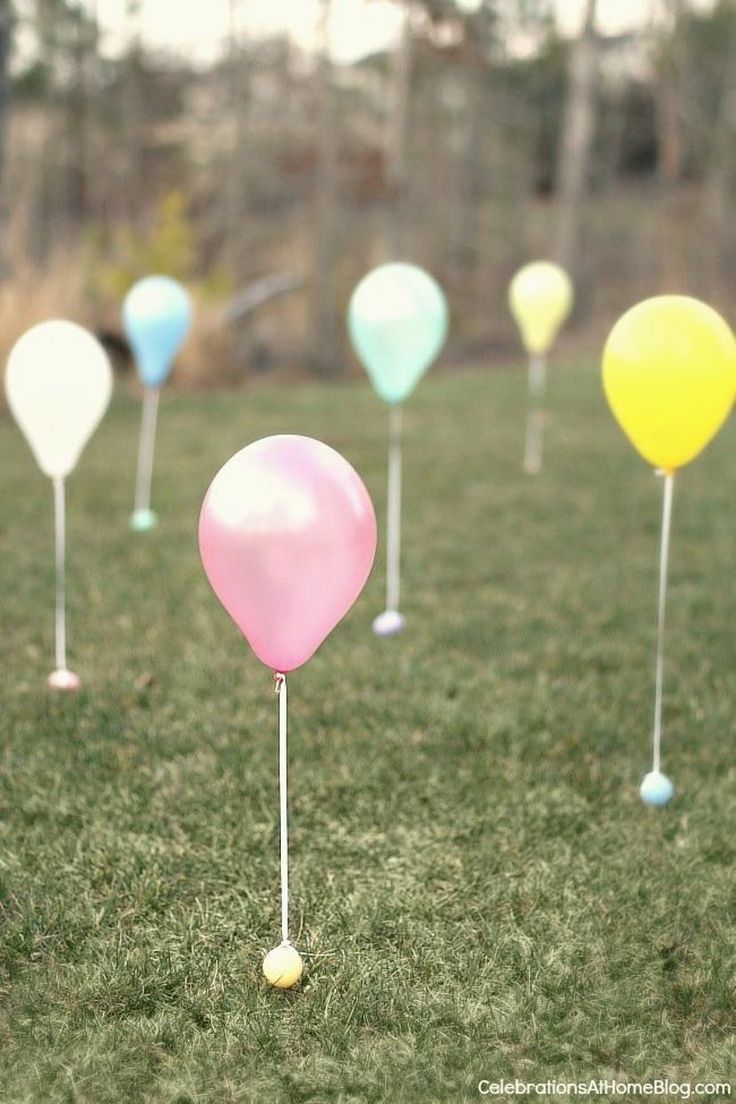 there are many balloons in the grass with one balloon stuck to it's side