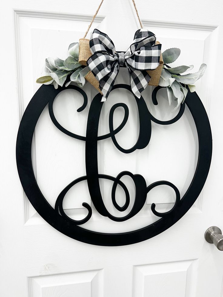 a monogrammed door hanger with a bow on it