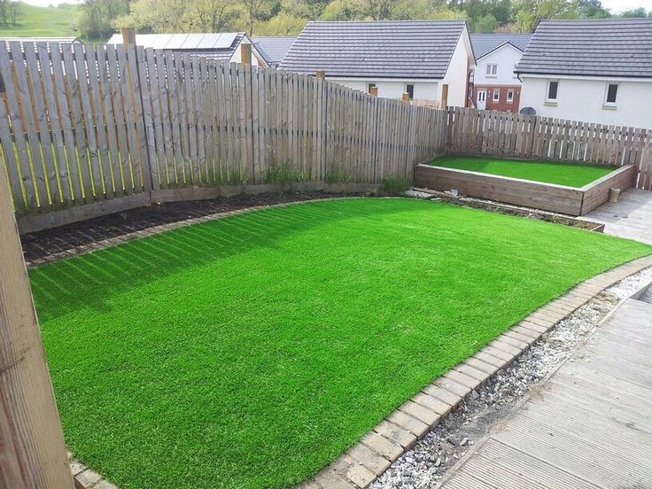 a backyard area with grass and wooden fence