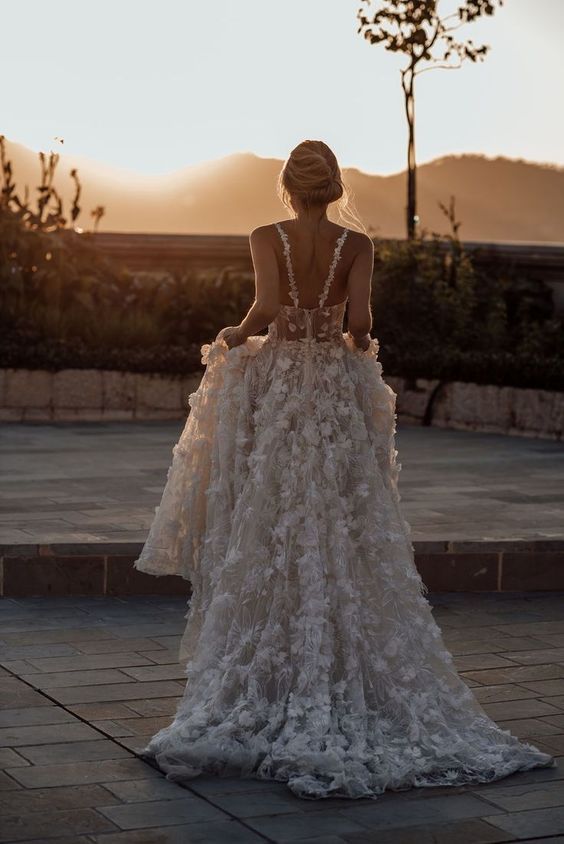 the back of a woman's wedding dress with ruffles on her skirt