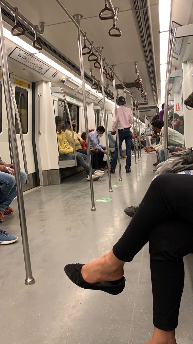 people are sitting on the subway train with their feet up