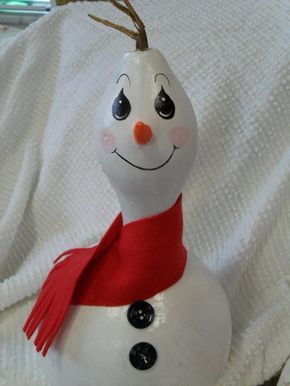 a white snowman ornament with a red scarf around it's neck