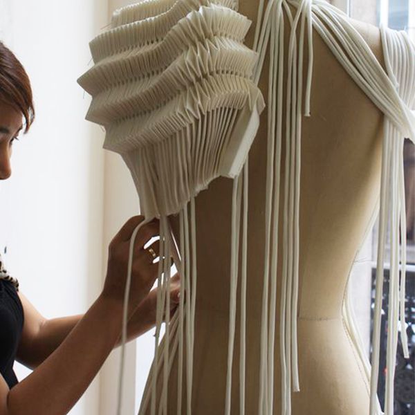 a woman is working on a dress form