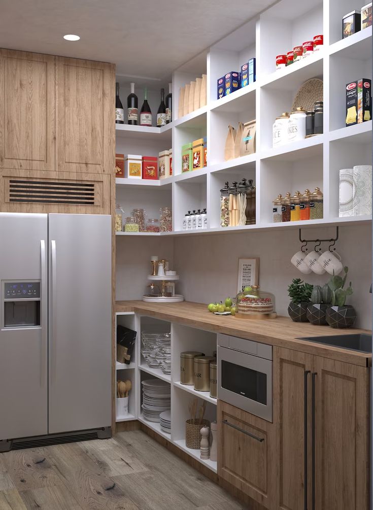 a kitchen with white shelving and lots of cupboard space next to a stainless steel refrigerator