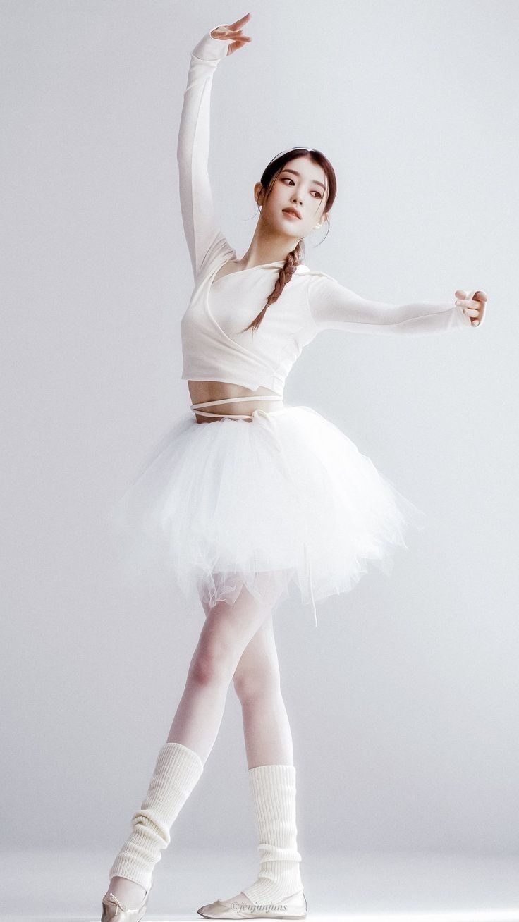 a young ballerina is posing for the camera