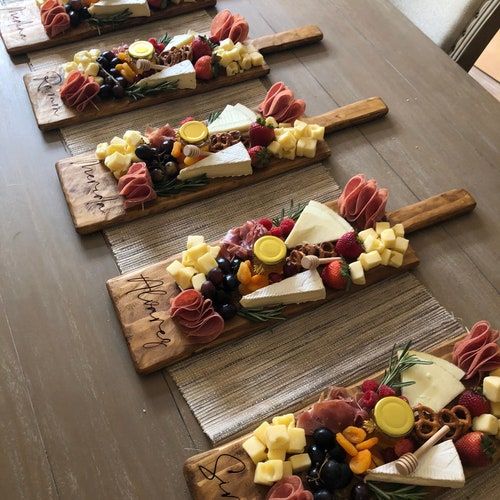 four wooden trays filled with different types of cheese and fruit on top of a table