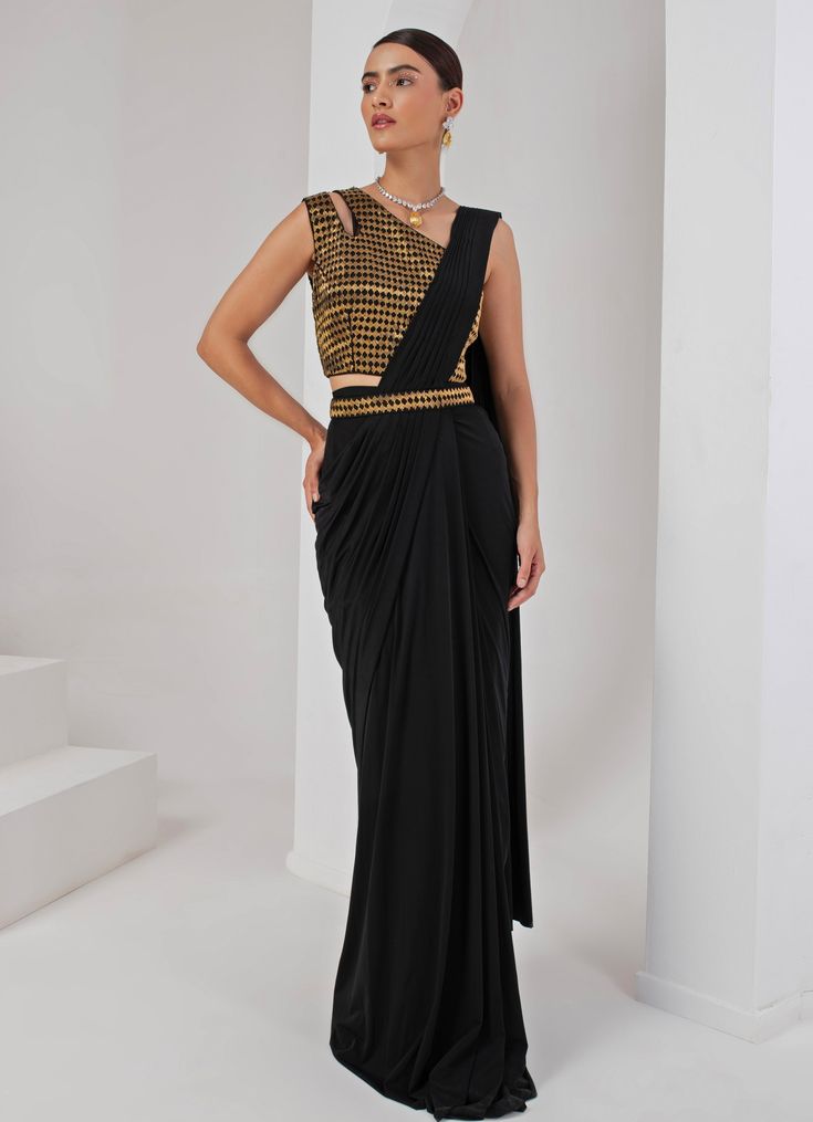 Introducing the stunning Black Pre-Draped Saree Set, crafted from luxurious lycra and crepe. This elegant black saree features beautifully pleated pallu detailing that creates a sophisticated drape, effortlessly merging modern convenience with the timeless grace of traditional attire. Paired with a chic sleeveless blouse, showcasing a contemporary one-shoulder neckline and adorned with intricate nalki embellishments that add a subtle shimmer. A hand-embellished belt cinches the waist, providing a stylish accent that perfectly ties the look together. Ideal for cocktails or high-end parties, this saree ensures you make a statement with its unique fusion of tradition and trend. Composition : Blouse - Crepe blend & Saree - Lycra Care: Dry Clean Only and Vacuum Storage This product can be custo Festive Fitted Pre-draped Saree For Gala, Elegant Black Pre-draped Saree For Evening, Fitted Draped Evening Sets, Formal Fitted Pre-draped Saree With Unstitched Blouse, Black Pre-draped Saree For Formal Party Wear, Fitted Pre-draped Saree For Gala Festivities, Formal Fitted Pre-draped Saree With Traditional Drape, Fitted Floor-length Saree For Gala, Black Saree For Evening