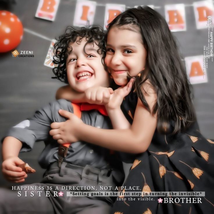 two young children are hugging each other in front of balloons and bunting streamers