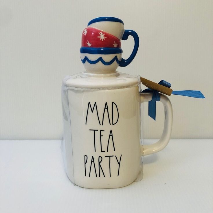 a ceramic mug with a tea pot on top and the words mad tea party painted on it