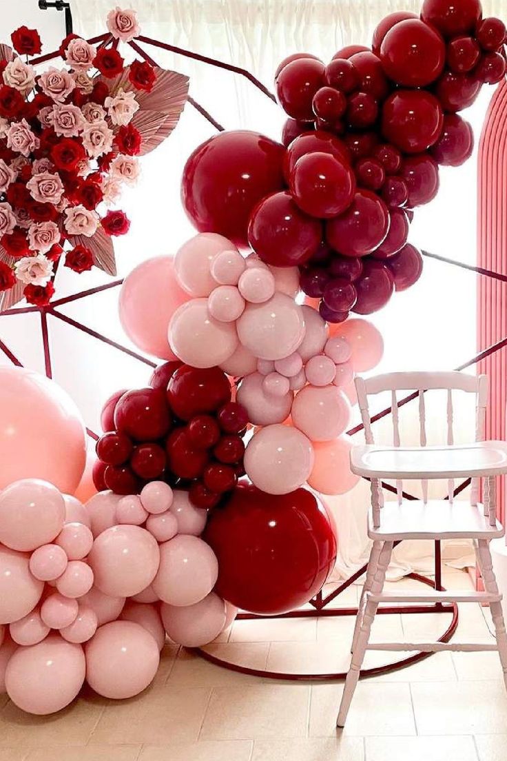 the balloon arch is decorated with pink, red and white balloons that are arranged on top of each other