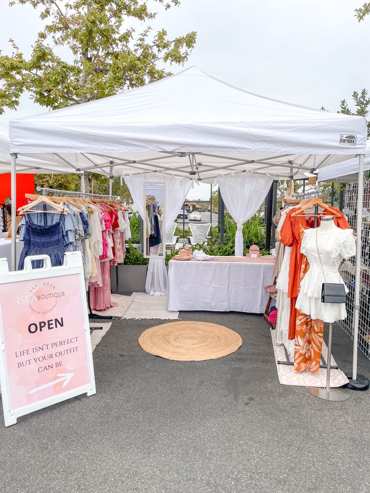 an open market tent with clothes on display