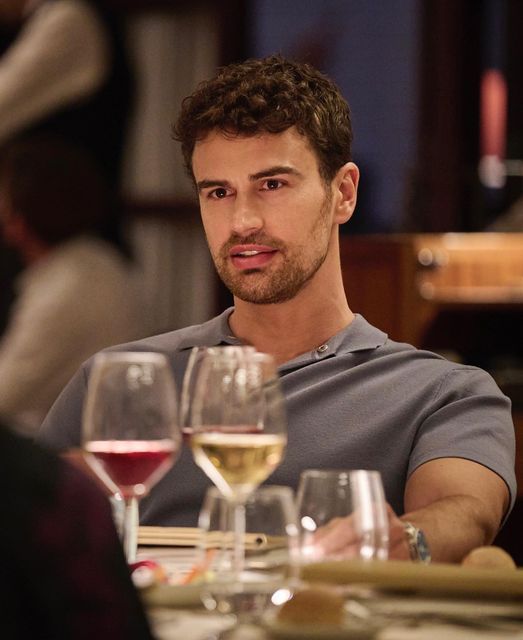 a man sitting at a table with wine glasses