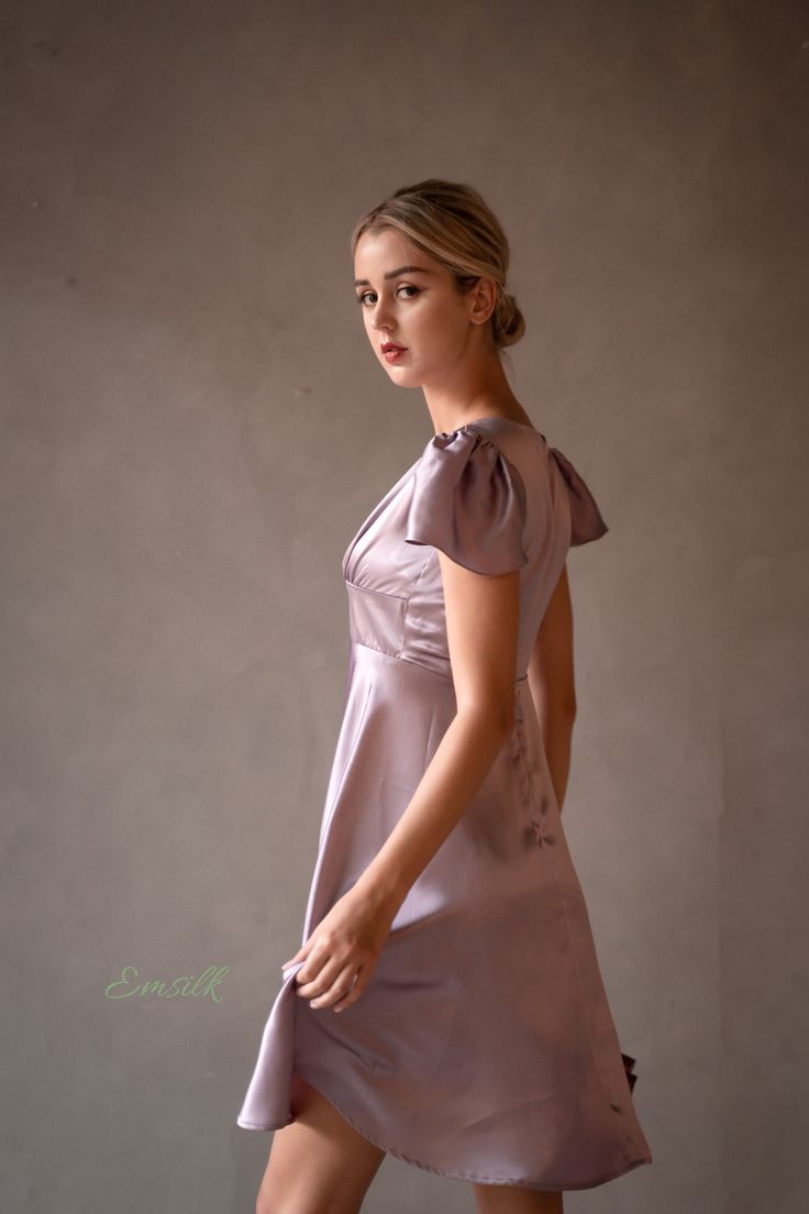 "This luxury lavender silk dress design is perfect for any occasions. 100 % designed and handmade by Emsilk. I am pleased to offer your garments made to measure at no extra cost. * Detail: - Deep V neckline with silk covered buttons detail - Fitted waist - Small puffed cap sleeves - Invisible zipper on the back. - Above the knee length -Best quality silk, 100 % pure 19mm Mulberry Silk which is made using traditional weaving techniques. This silk hugs your body tenderly and you will not want to t Elegant Lavender A-line Dress, Feminine Satin Knee-length Mini Dress, Feminine Silk Knee-length Mini Dress, Feminine Silk Mini Dress With V-neck, Feminine Knee-length Silk Mini Dress, Elegant Mauve V-neck Mini Dress, Feminine Fitted Silk Knee-length Dress, Feminine Satin Mini Dress With Short Sleeves, Feminine Short Sleeve Satin Mini Dress