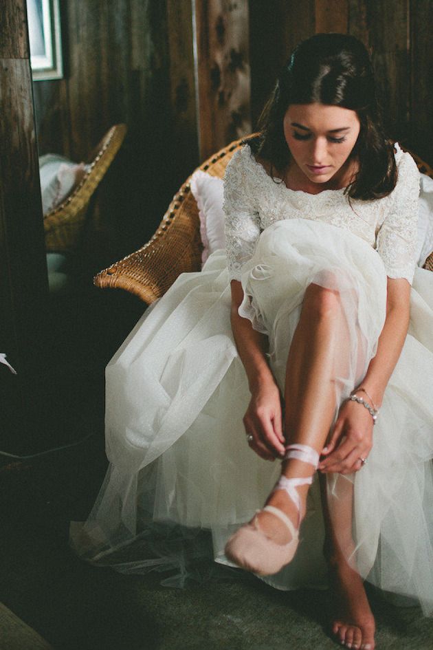 a woman sitting on top of a chair in a white dress and heels with her feet up