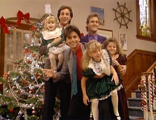 a group of people standing in front of a christmas tree