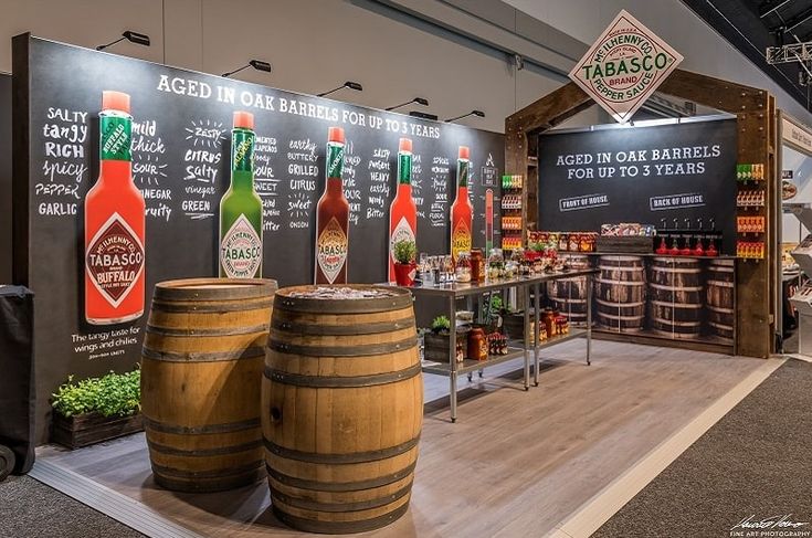 a display in a store filled with lots of bottles and wooden barrels sitting on the floor