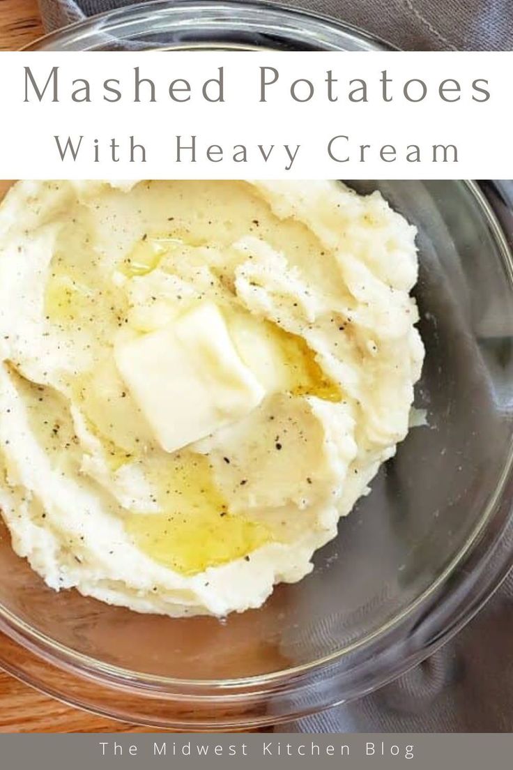 mashed potatoes with heavy cream in a glass bowl on top of a wooden table