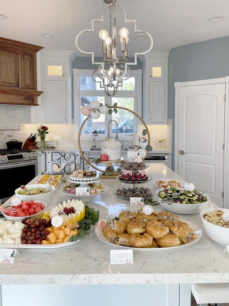 a kitchen counter topped with lots of plates and bowls filled with different types of food