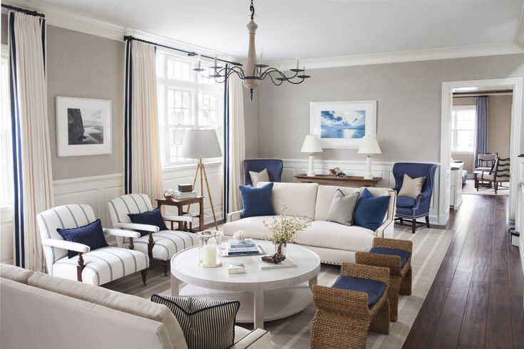 a living room filled with white furniture and blue accents