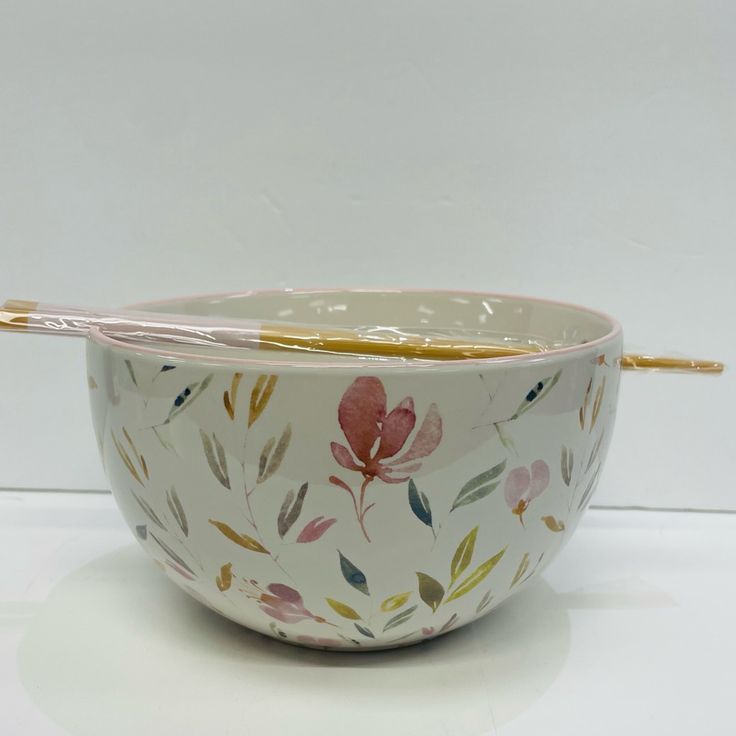 a white bowl with pink flowers and gold trim