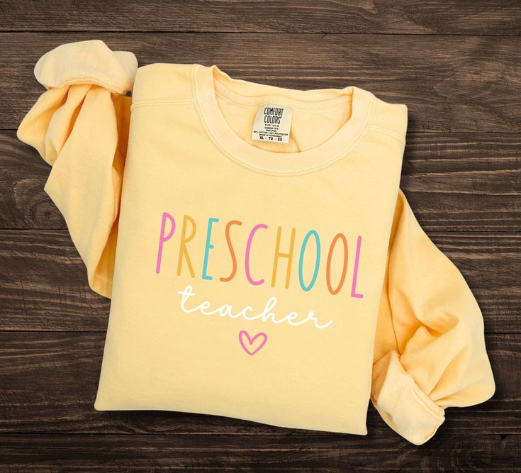 Preschool Teacher Sweatshirt, Comfort Colors, Back To School, Teacher appreciation, Prek Teacher Sweatshirt, Preschool Teacher Gift Luxurious comfort and style are what this unisex, garment-dyed sweatshirt is all about. It's made with 80% ring-spun cotton and 20% polyester and the fabric is 3-end garment-dyed, ring-spun, color-blast fleece with a 100% cotton face. Each sweatshirt comes with a relaxed fit, a rolled-forward shoulder, and a back neck patch.  .: 80% ring-spun cotton, 20% polyester . Long Sleeve Tops For End Of School Year Events, Long Sleeve Tops For School Events, End Of School Year Long Sleeve T-shirt, Long Sleeve T-shirt For End Of School Year, Long Sleeve Cotton Top For School Events, Long Sleeve Cotton Tops For School, Cotton Long Sleeve Tops For School Events, School Crew Neck Sweatshirt With Name Print, Cute Long Sleeve College T-shirt