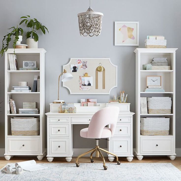 a white desk with a pink chair in front of it and some pictures on the wall