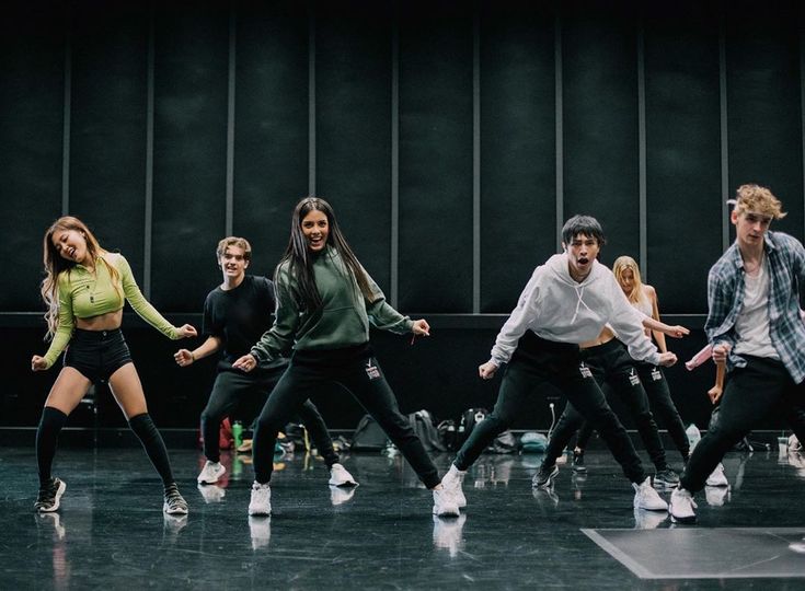 a group of young people standing on top of a dance floor