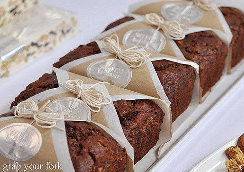 there is a loaf of bread on the table with other pastries around it and another piece of cake in the background