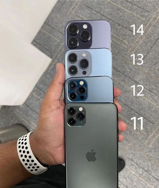 four iphones in different colors being held by someone