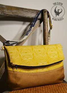 a yellow and brown purse sitting on top of a wooden chair