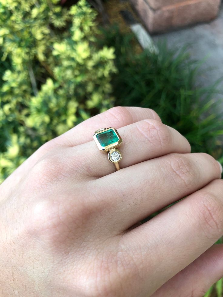 A classic Colombian emerald and diamond three-stone ring. Dexterously crafted in gleaming 14K gold this ring features a natural Colombian emerald-Asscher cut from the famous Muzo mines. Set in a secure bezel setting, this extraordinary emerald has a bright green color and glow. This emerald has very good eye clarity with natural Jardins that occur in all earth-mined emeralds. Brilliant round cut diamonds weigh an outstanding 0.45 total carat weight. Elegantly accenting either side of the emerald 14k Gold Asscher Cut May Birthstone Ring, Elegant Emerald Cut Three Stone Birthstone Ring, Timeless Green Jewelry With Bezel Setting, Elegant 14k Stamped Emerald Ring, Green Three Stone Emerald Cut Jewelry, Timeless Diamond Emerald Ring With Bezel Setting, Formal Three Stone Emerald Cut Birthstone Ring, Formal Three-stone Emerald-cut Birthstone Ring, Emerald Cut Three Stone Birthstone Ring For Formal Occasions