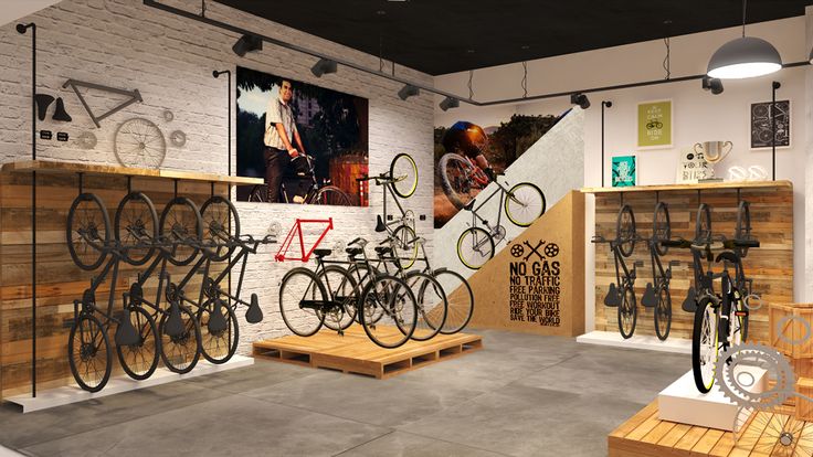 an indoor bike shop with lots of bikes hanging on the wall and wooden benches in front of them