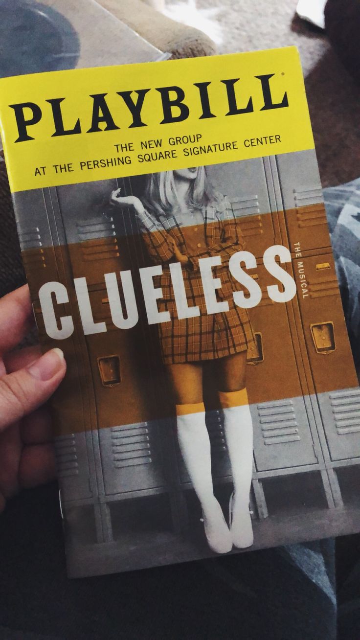 a person is holding up a book about clueless in front of their face and legs