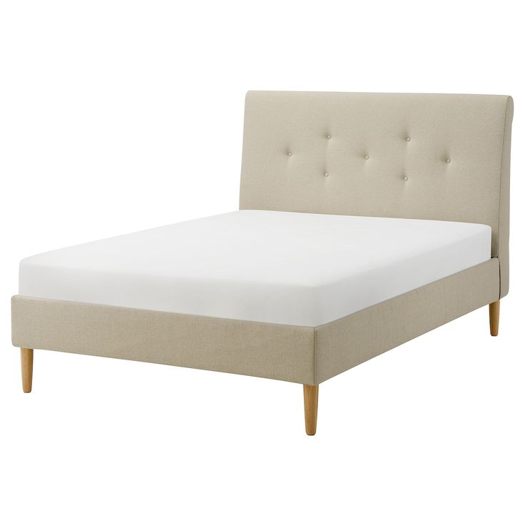 an upholstered bed with white sheets and wooden legs