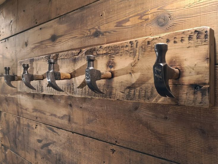 a wooden wall with several different types of tools hanging from it's hooks on the side