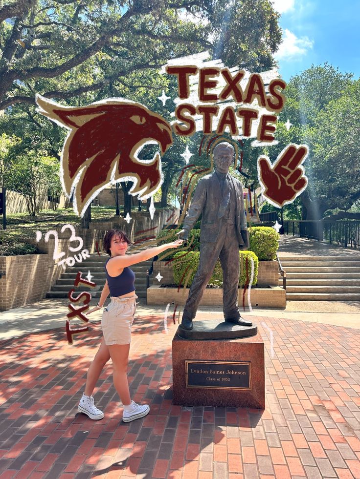 a woman pointing at a statue of a man with the word texas state on it