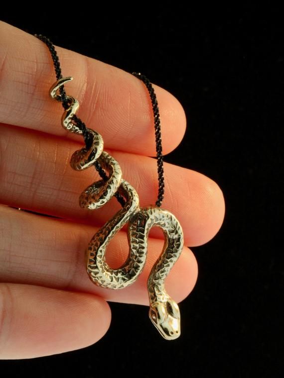 This sinuous Python Snake winds gracefully along and down the chain as if it were suspended from a vine. The bronze snake is 2 1/4" long and completely three dimensional with detailed scales and belly plates. Slither home with this striking beauty! The Bronze Python Snake includes a 24" black cord but you may upgrade to an 18" black sparkle chain via the drop down menu.This item usually ships the same or next business day.All Marty Magic Jewelry is packaged in a beautiful box, embossed with the Spiritual Brass Snake-shaped Jewelry, Spiritual Snake-shaped Metal Jewelry, Spiritual Metal Jewelry In Snake Shape, Spiritual Brass Jewelry In Snake Shape, Symbolic Snake-shaped Brass Jewelry, Unique Snake-shaped Metal Jewelry, Adjustable Snake Shape Chain Jewelry, Unique Metal Jewelry With Snake Shape, Bronze Snake-shaped Jewelry Gift