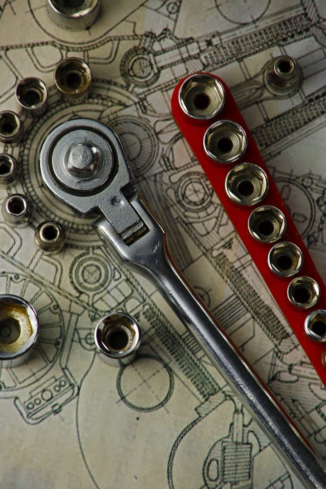 a pair of wrenches sitting on top of a table covered in lots of screws