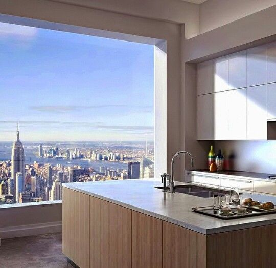 a kitchen with a large window and a view of new york city in the background