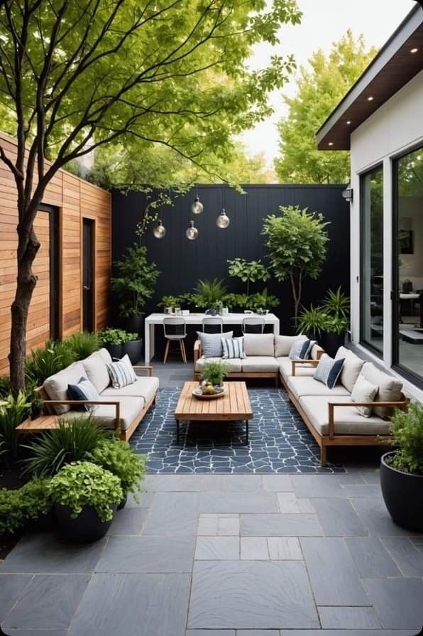 an outdoor living area with couches, tables and potted plants on the patio