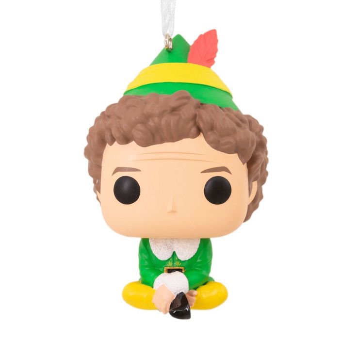 a figurine is sitting on the floor with a green shirt and yellow hat