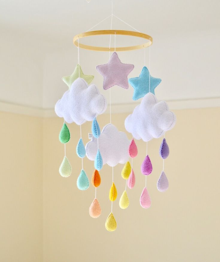 a crib mobile with clouds, stars and raindrops hanging from the ceiling