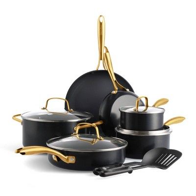 an assortment of black pots and pans with gold handles on a white background,