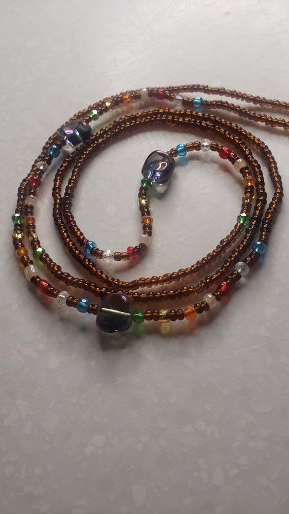 Thick (1mm) strand of tie on method waistbeads. Made in Ghana. Measures 42'' Can also be worn as a double necklace, low hanging necklace, wrap anklet or bracelet.  https://www.healthline.com/health/beauty-skin-care/waist-beads-modern-uses#5-reasons-to-wear-waist-beads Cheap Handmade Adjustable Waist Beads, Belly Chain Body Jewelry, Chain Body Jewelry, Hanging Necklaces, Double Necklace, African Necklace, Layered Chokers, Necklace Layered, Waist Beads