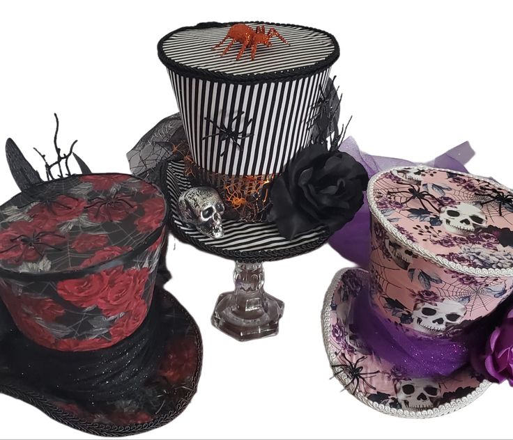 three hats with different designs on them and one is black, the other has red roses