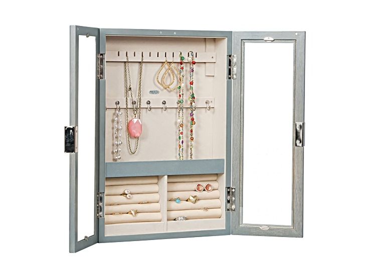 an open jewelry cabinet with several necklaces and rings on it's doors,